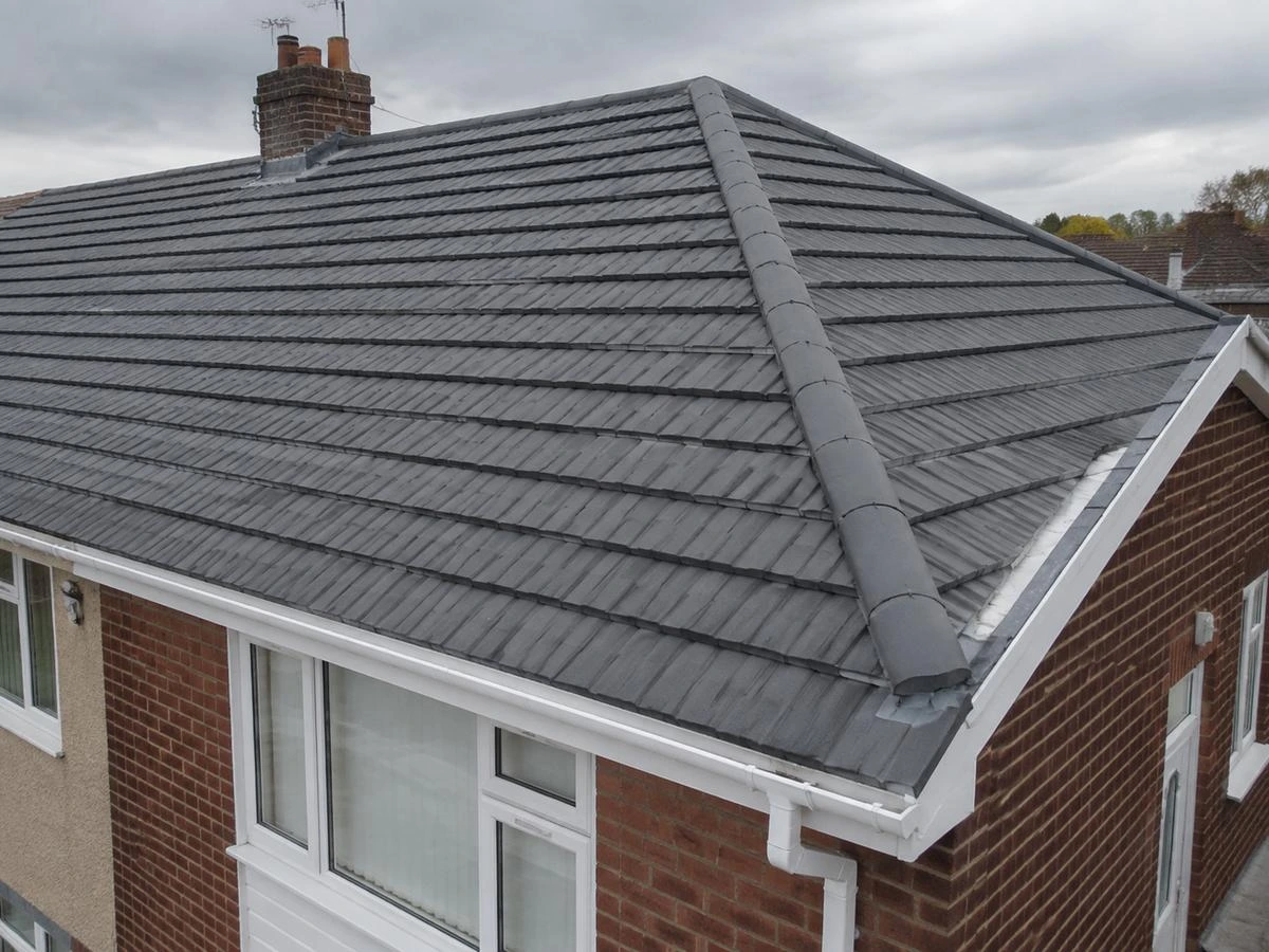A recovered hipped roof in interlocking concrete tile, with the ridge and hip lines bedded straight